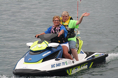 A Special Olympics Michigan athlete receives a ride on a personal watercraft from a Water Warriors member.