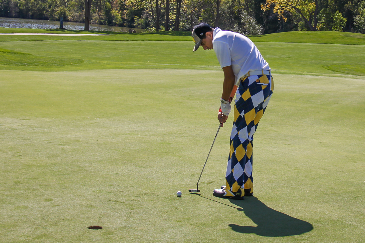 A Special Olympics Michigan golfer prepares to putt