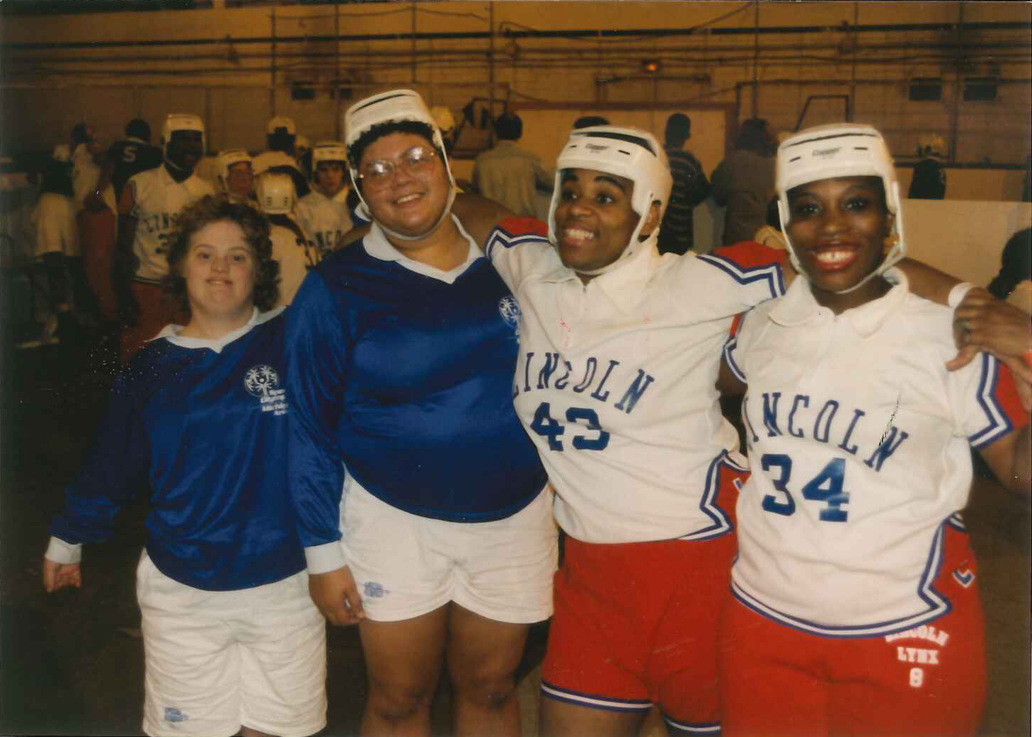 Four Special Olympics Michigan Poly Hockey players smile for the camera.