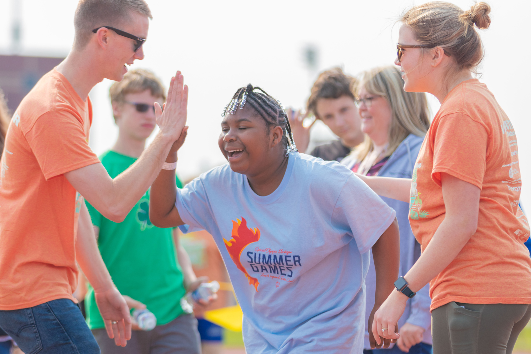 Volunteers congratulate a Special Olympics Michigan athlete.