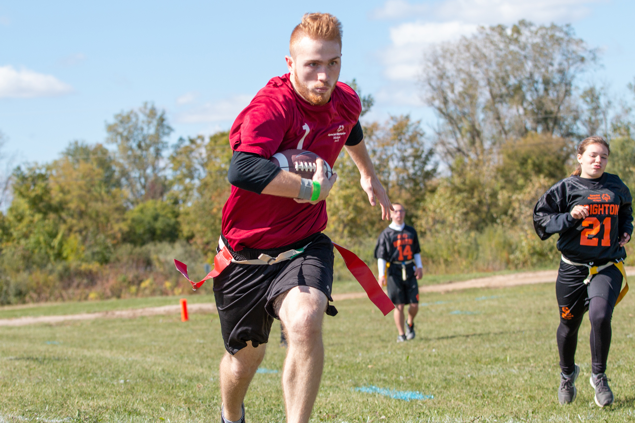 A football player runs down the sideline with the ball.