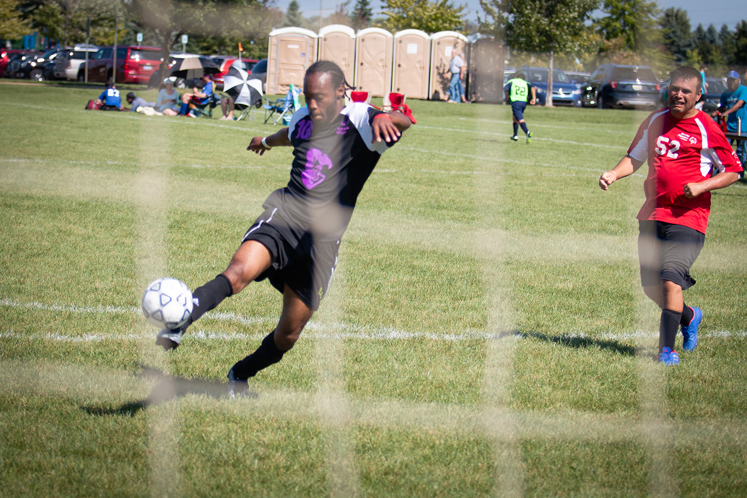 A soccer athletes takes a shot on goal.