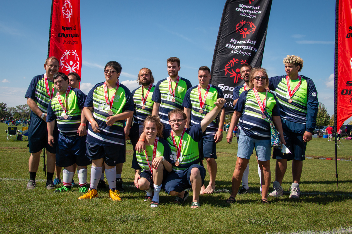 A soccer team celebrates after receiving silver medals.