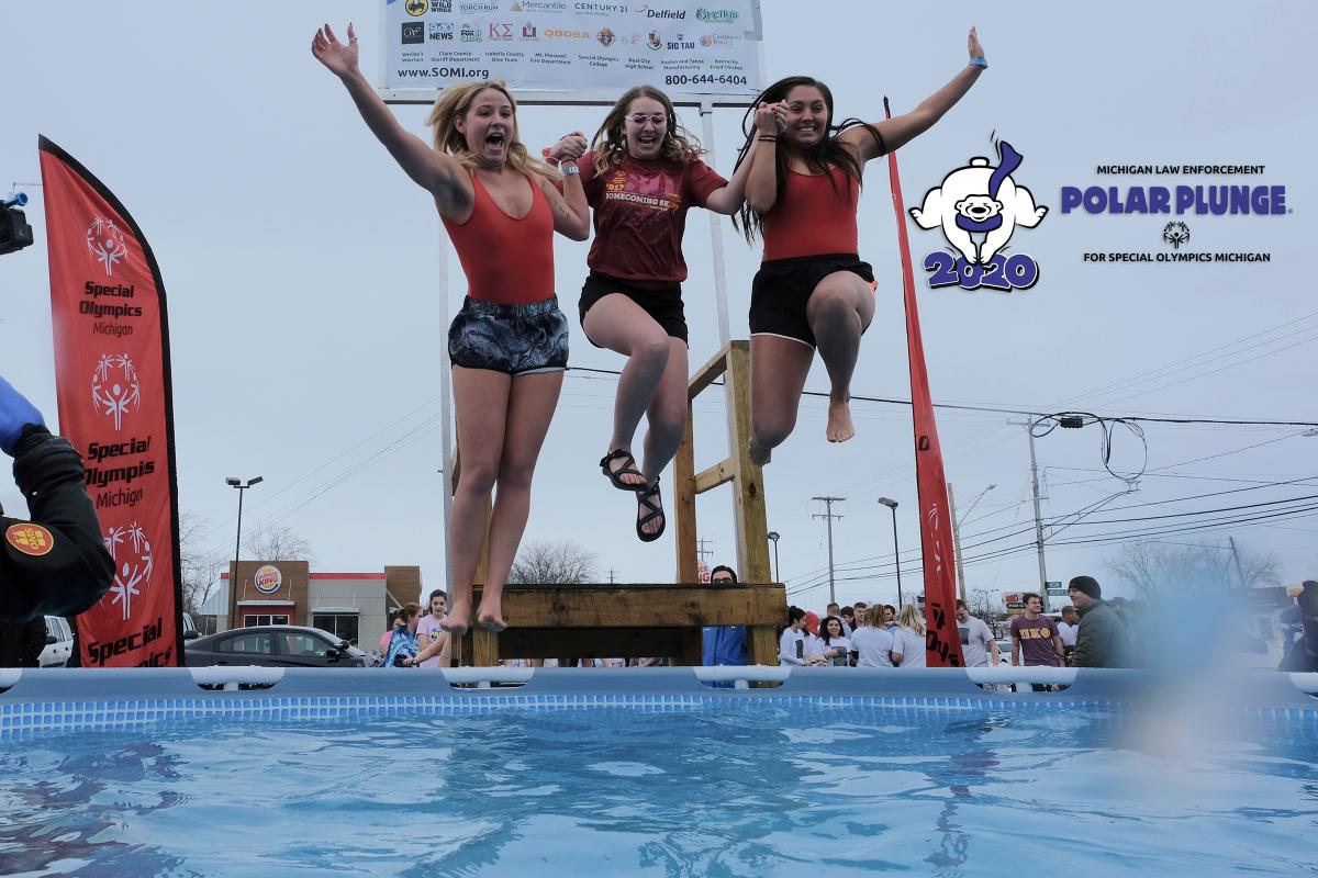 Three women jump into a pool of water during a Polar Plunge.