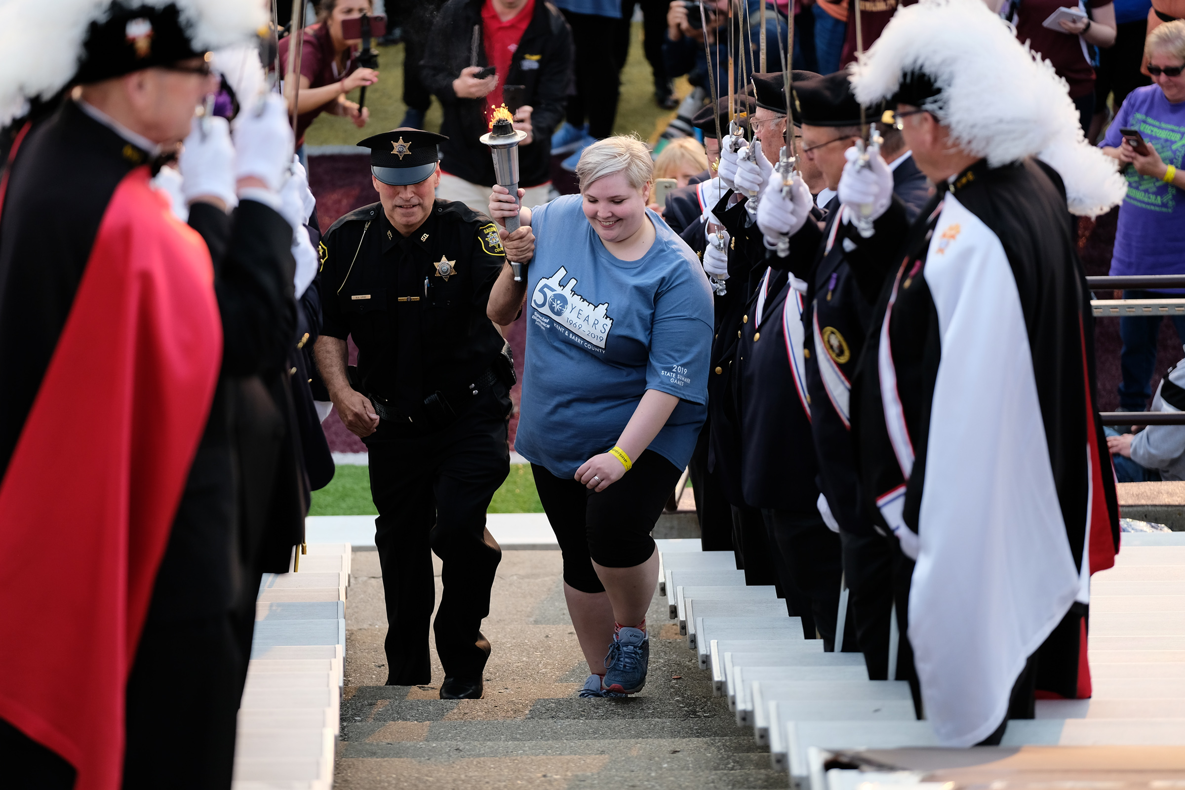 A Law Enforcement Officer and SOMI athlete prepare to light the Flame of Hope at the State Summer Games.