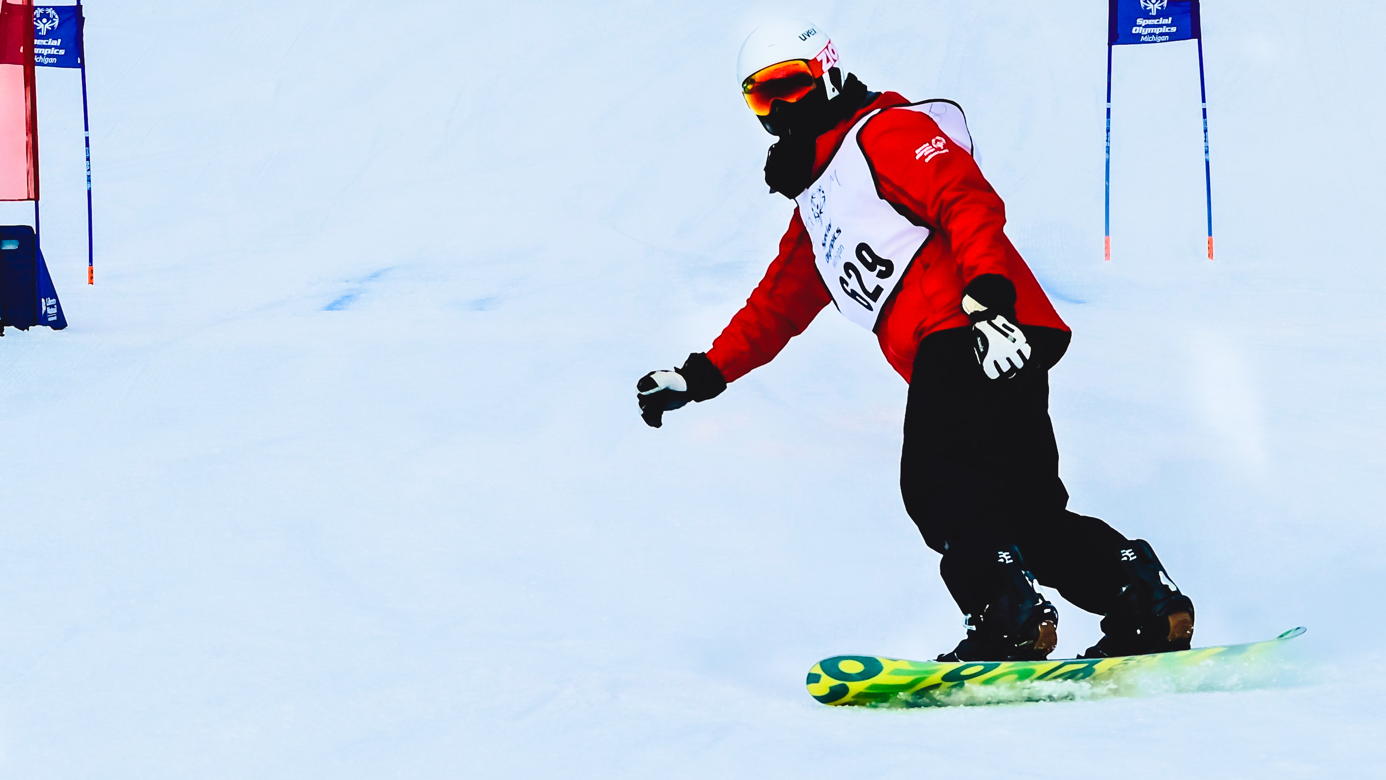athlete going down the hill on a snowboard