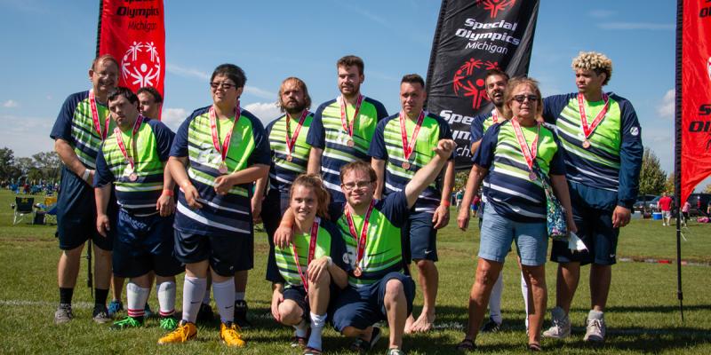 A soccer team celebrates after receiving silver medals.