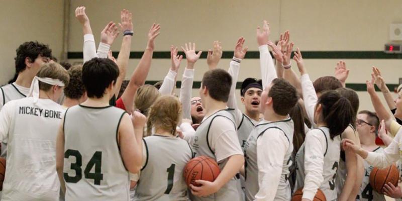 Howell High School Students huddle up during a basketball game