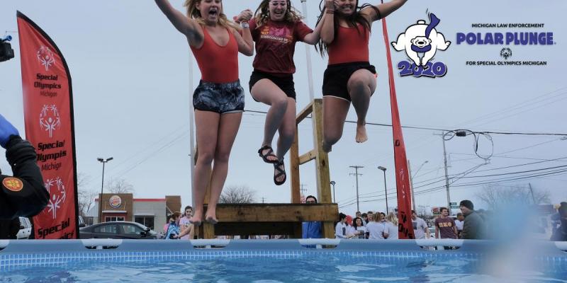 Three women jump into a pool of water during a Polar Plunge.