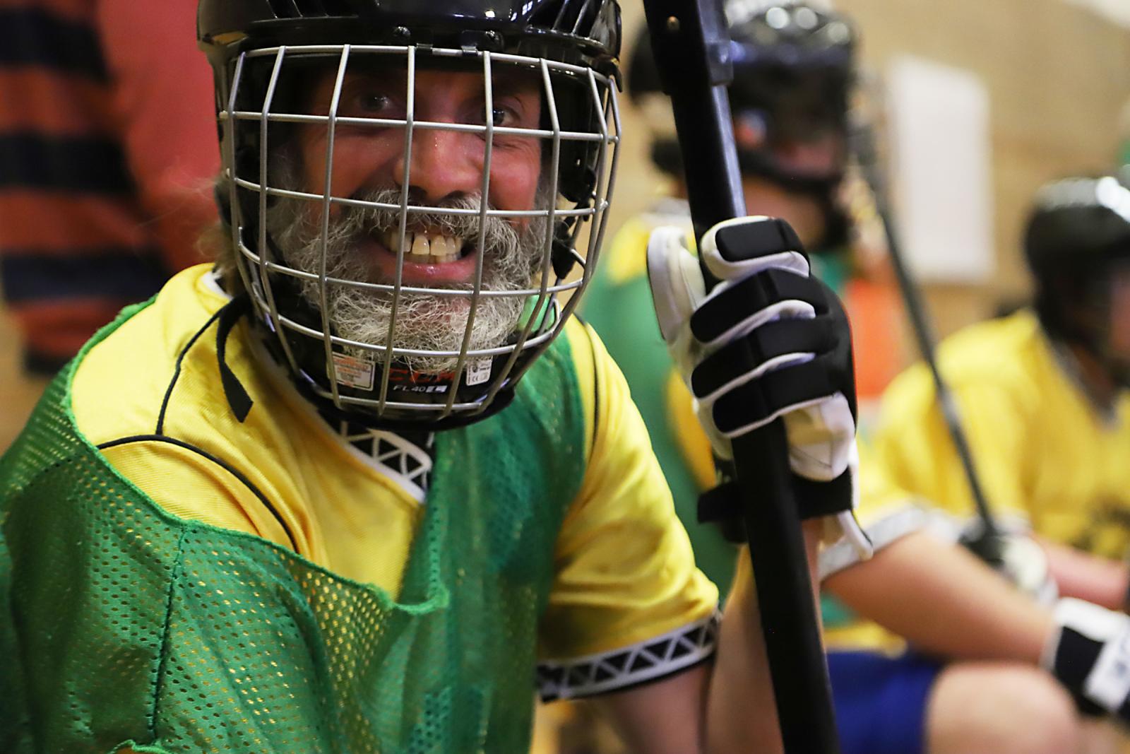 A Special Olympics athlete wearing a hockey mask smiles